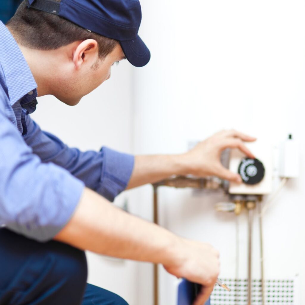 plumber adjusting water heater