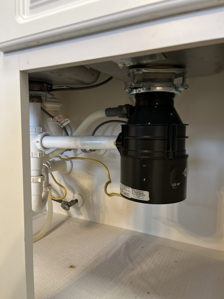 Garbage disposal installed under a kitchen sink by Conner Plumbing of the Midlands in Irmo, SC